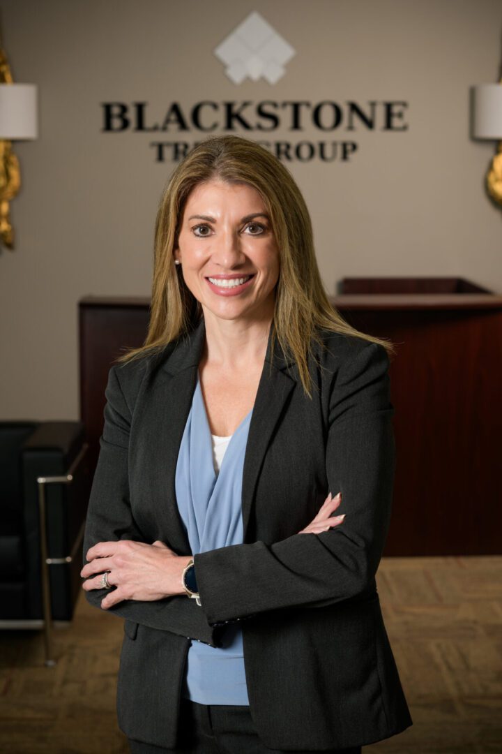 Confident businesswoman standing with arms crossed in office.